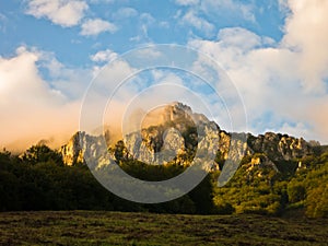 Rocky peaks at foggy sunrise, trekking path at Suva Planina mountain