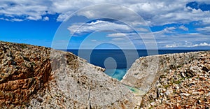 Rocky red cliffs of typical Greek view, azure sea, clear blue sky, beautiful sky. Stefanou beach, Seitan Limania