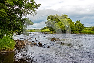 A rocky riffle under trees on a summers day on the River Dee, Galloway, Scotland