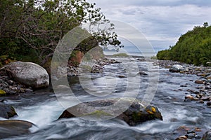 The rocky river flows into the sea.