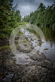 Rocky Riverbank Under Overcast Sky