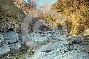 Rocky riverbed with a small creek under the setting sun.