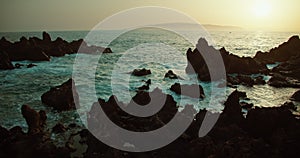 Rocky rough sea coastline in Tenerife at sunset. Volcanic beach Charco el Diablo, Spain.