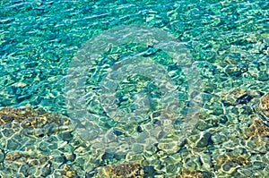 Rocky sea floor and crystal clear turqoise water photo