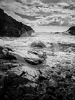 Rocky sea shore on a cloudy day in Black and white photo