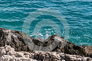 Rocky sea shore and sea foam, Adriatic sea detail during summer day