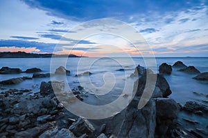 Rocky seascape at sunrise with waves flowing over harsh granite rocks