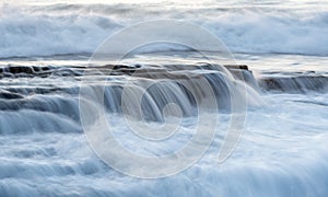 Rocky seashore with wavy ocean and waves crashing on the rocks