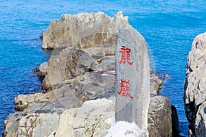 Rocky seaside of Haedong Yonggungsa Temple with a stone signage with the chinese calligraphy as Dragon Rocks in Busan