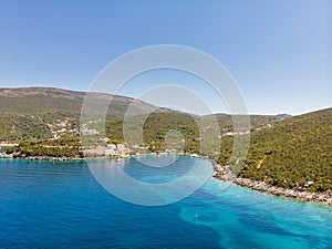 Rocky seaside near Veslo camping in Montenegro. Azure blue water, white waves hitting the rocks, sunny summer day.