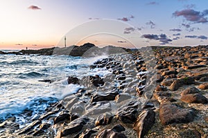 Rocky shore of the coast of Bude, Cornwall, England, in the sunset, blurred water by long time exposure