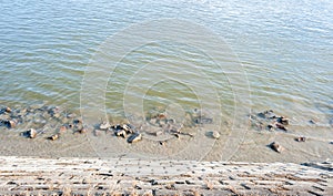 Rocky shore on Danube river with green water view from above