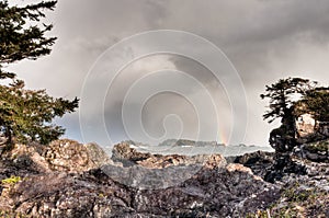 Rocky Shore With Distant Rainbow