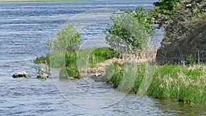 Rocky shore of the lake with grass.