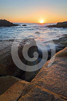 a rocky shore next to a body of water in South West Rocks in Australia