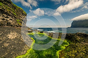 Rocky shore with small sea ponds near village Mikladalur, Kalsoy island, Faroe Islands photo