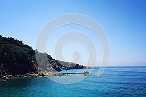 Rocky shore. Southern coast of Turkey. Calm blue sea and clear sky.