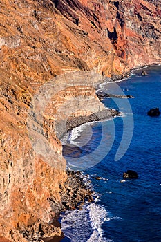 A rocky shoreline with a blue ocean in the background