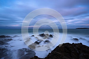 Rocky shoreline blue ocean sunset surf seascape long exposure