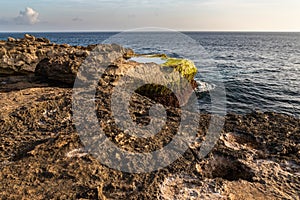 Rocky Shoreline, Devil`s Tear, Nusa Lembongan, Bali. Rocks and tidepool in forground; Ocean, shorline, clouds, sky beyond.