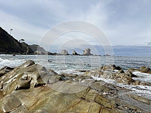 Rocky shoreline with distant cliffs and serene waters