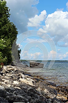 The rocky shoreline of Lake Michigan, with a rocky outcropping, in the summer in Cave Point County Park