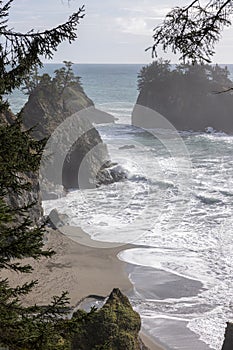 A rocky shoreline with a rocky cliff in the background