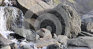 A rocky shoreline with a waterfall