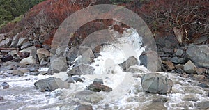 A rocky shoreline with a waterfall