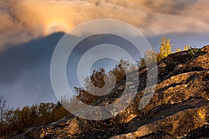 Skalnatý svah s bujnou vegetáciou na pozadí mrakov. Kremnické vrchy, Slovensko.