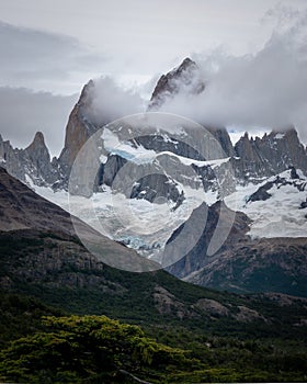 Rocky snowy mountain peaks with the sun rising behind and red clouds. Fitz Roy in Argentina