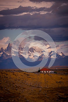 Rocky snowy mountain peaks with the sun rising behind and red clouds. Fitz Roy in Argentina