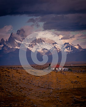 Rocky snowy mountain peaks with the sun rising behind and red clouds. Fitz Roy in Argentina