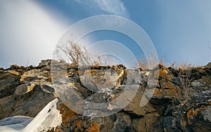 Rocky steep bank near the lake in winter.