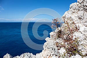 Rocky steep cliff close-up on blue Ionian seascape