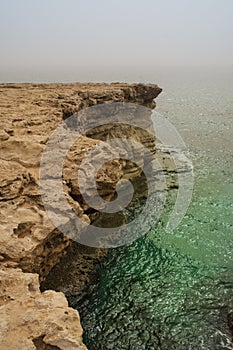 Rocky steep cliff of Cyprus coast to deep blue green Mediterranean sea