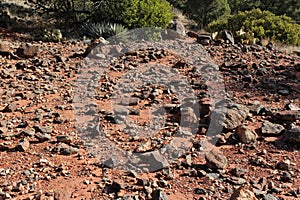 The rocky strewn trail of red dirt of the Soldier\'s Pass Trail lined with Prickly Pear Cacus, Yucca, shrubs and grasses