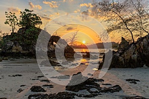 Rocky tropical coastline at sunset