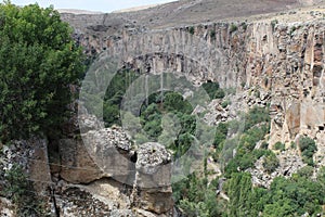 Rocky valley under a ledged cliff of gray rocks