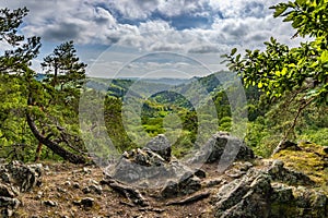 Rocky viewpoint over valley and surrounding spring forests under blue sky photo
