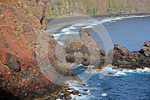 A rocky and volcanic landscape, viewed from a hiking path leading to Playa de Nogales