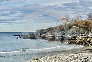 Rocky, white, ocean beach and cove with large rocks at the side