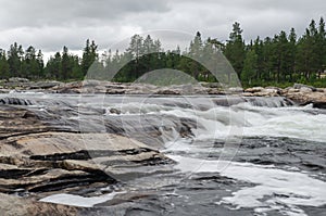 Rocky whitewater river with rapids and forest