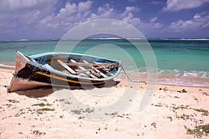 RODRIGUES ISLAND, MAURITIUS: A fishing boat on the beach and the colorful Indian Ocean