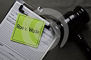 Roe v. Wade on sticky notes and gavel isolated on office desk. Law concept