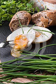Roeasted Round Eggs with Fresh Bread on Black Stone Board