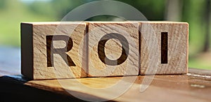 ROI Return on Investment written on a wooden cubes. financial business concept