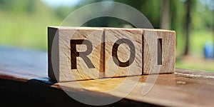 ROI Return on Investment written on a wooden cubes. financial business concept