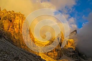 Roky cliff mountains of Dolomites yellow color at sunset