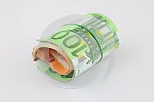 Roll of 100, 50, 20 and 10 euro banknotes with a rubber band